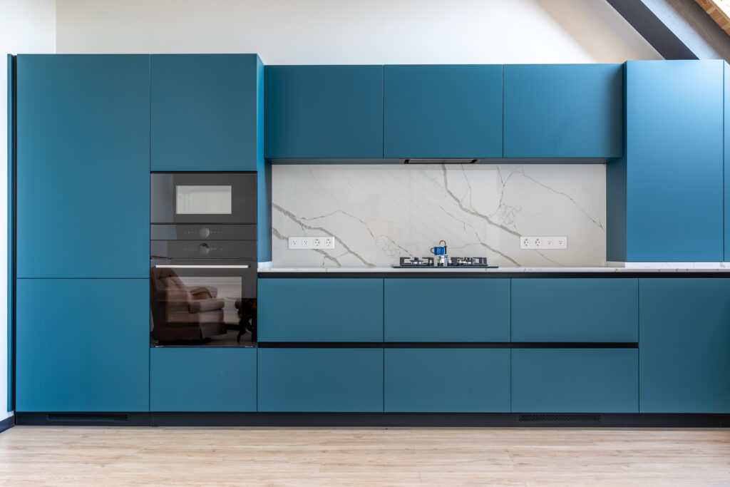 kitchen with gas stove. marble wall. matte blue cabinetry.