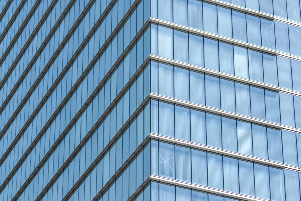 Close-up of a modern glass building facade showcasing geometric lines and reflections.